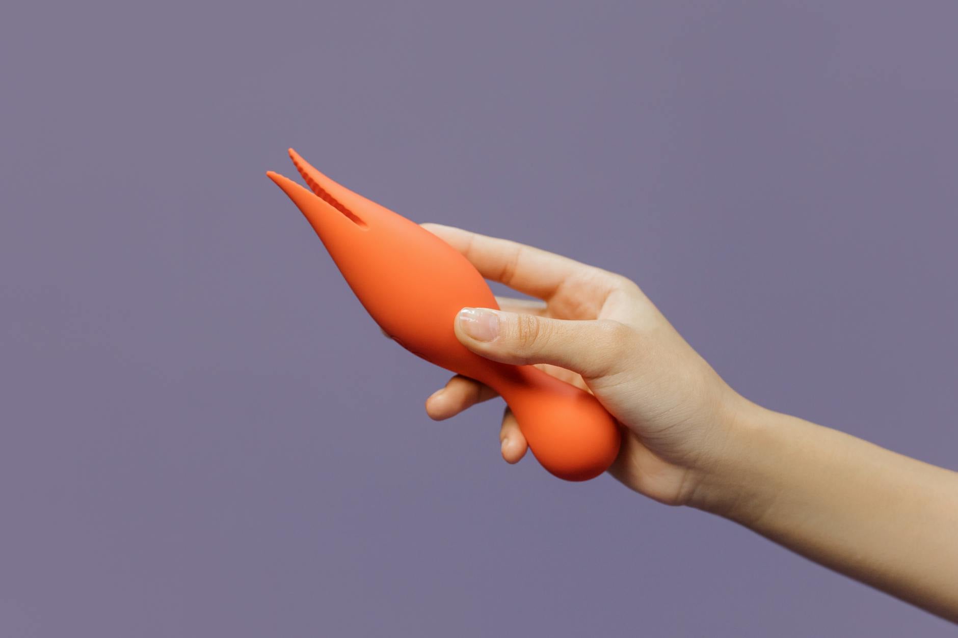 A person holding a yellow lemon vibrator in their hands, representing taking control of pleasure without judgment.