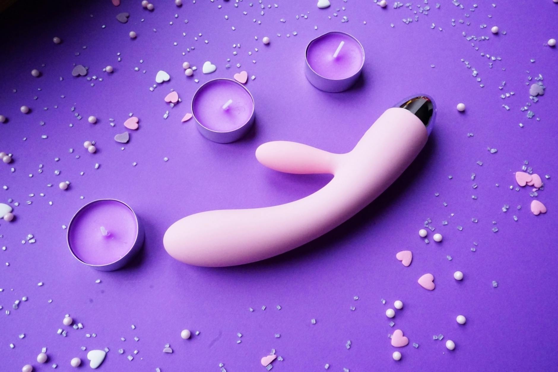 Woman holding vibrators in a contemplative pose, symbolizing body reconnection and self-care